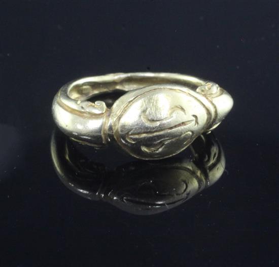 An antique yellow metal ring, the oval head carved with initials, possibly Roman,